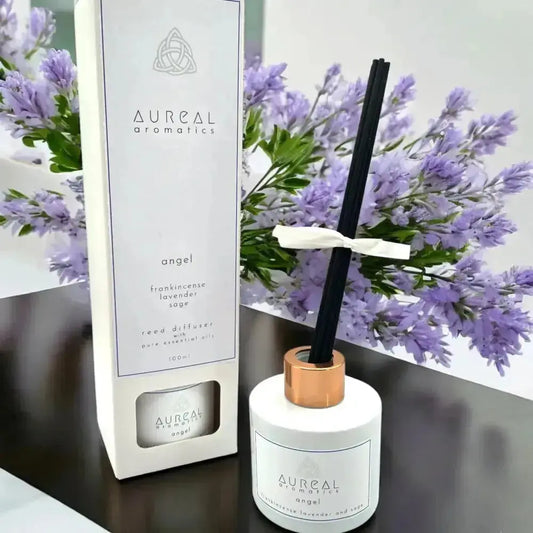 Aureal Angel reed diffuser in a white bottle with black reeds and its box, lavender behind