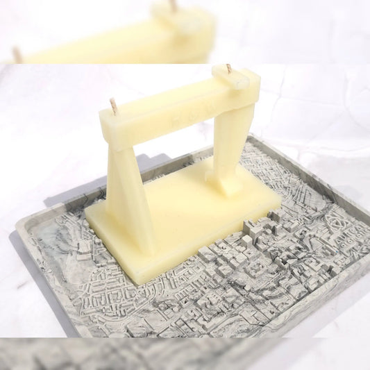 Harland and Wolff candle: a cream crane shape with two wicks on a grey marbled base with a raised street map