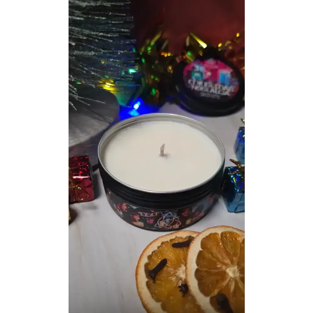 Open Christmas Nostalgia tin candle with dried orange slices and wrapped gifts