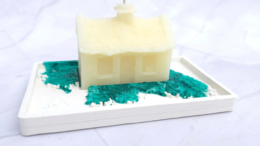 Cream beeswax Irish cottage candle on a white base with a green marbled pattern