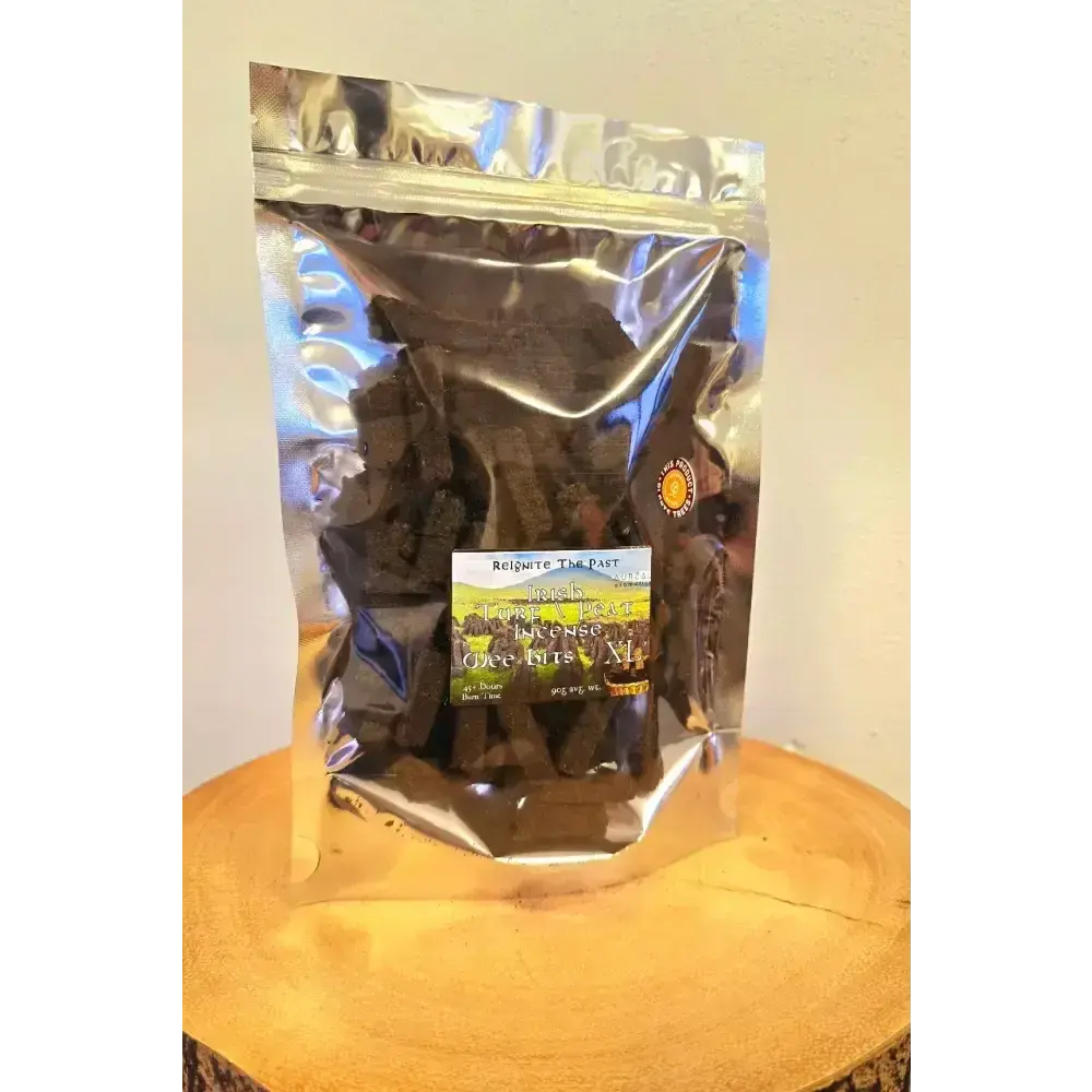 Silver resealable bag of Irish Turf Peat Incense Wee Bits on a wood slice