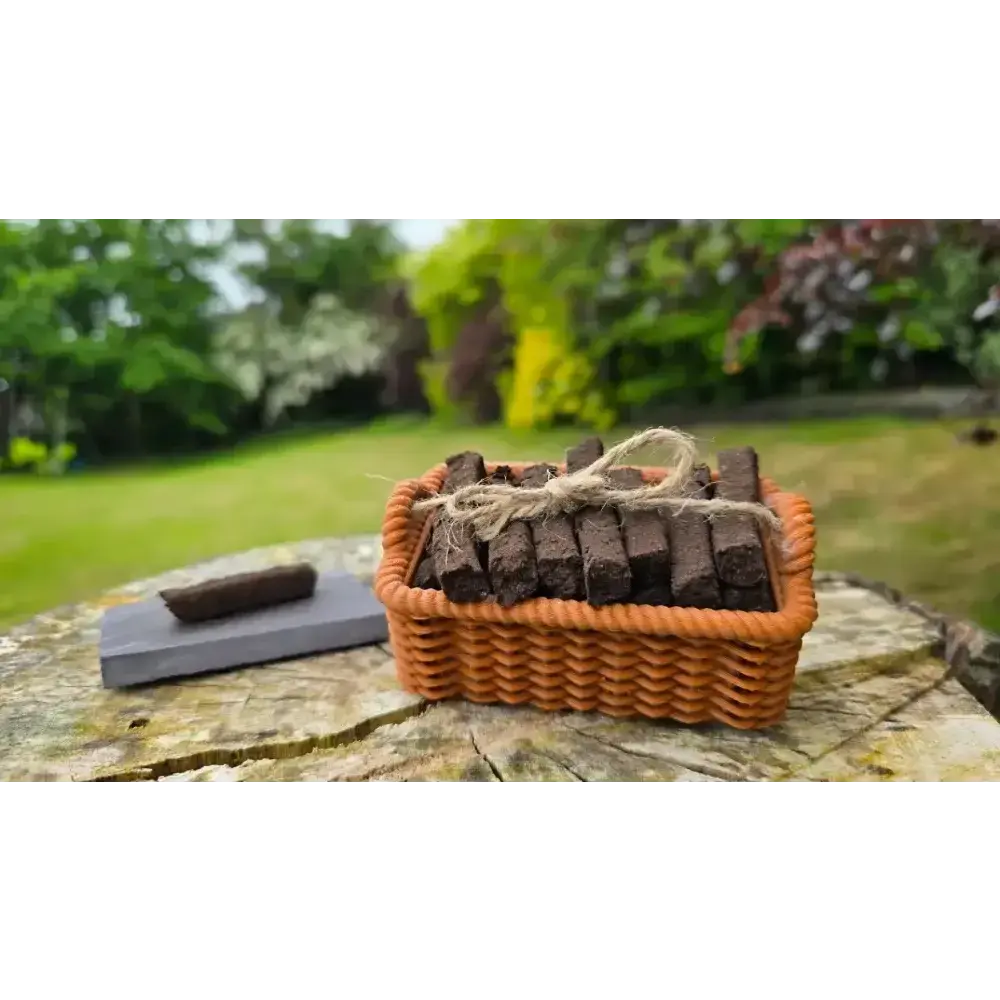 Brown basket of turf sods tied with twine and a sod on a slate, on a tree stump outdoors