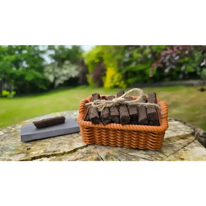 Brown basket of turf sods tied with twine and a sod on a slate, on a tree stump outdoors