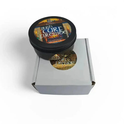 Irish Turf Fireside candle tin on top of a white gift box with a round sticker