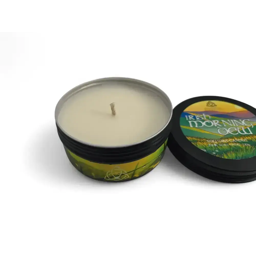 Irish Morning Dew candle in a black tin with its lid beside it