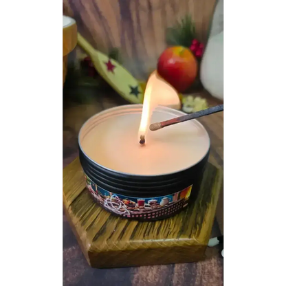 Nanny's Kitchen tin candle being lit with a match on a hexagon wooden stand