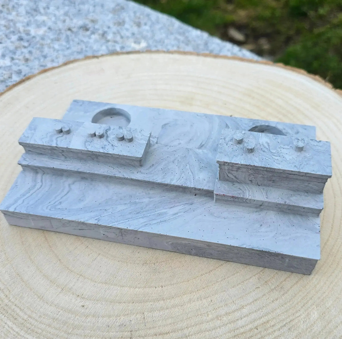 Empty grey stone effect Poolbeg candle base with two round holders, on a wood slice