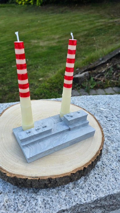 Poolbeg chimney candles in their grey stone effect base on a wood slice outdoors