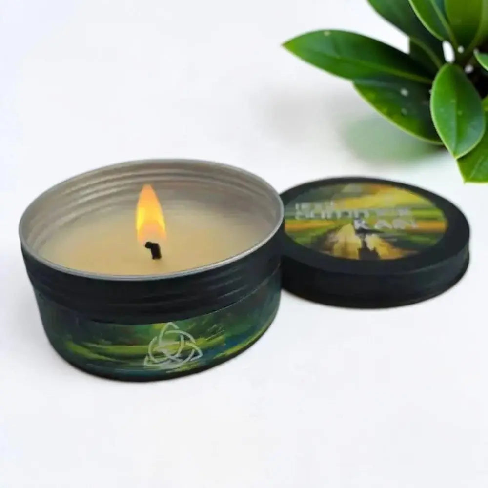 Lit Irish Summer Rain candle in a black tin with its lid beside it