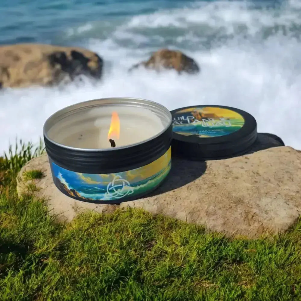Lit Wild Atlantic Way tin candle on a rock with waves behind